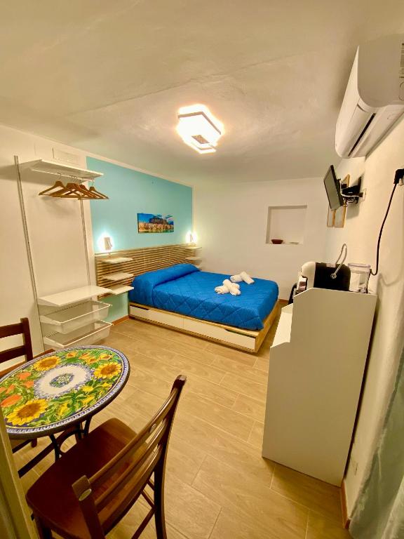 a bedroom with a blue bed and a table and a tableablish at Appartamento Osnao in Cefalù