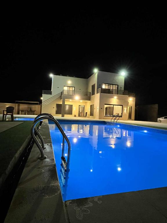 a swimming pool in front of a house at night at Green view in Al Mazār