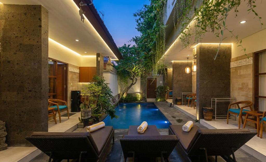 a swimming pool in the middle of a house at Naksa Homestay Sanur in Sanur