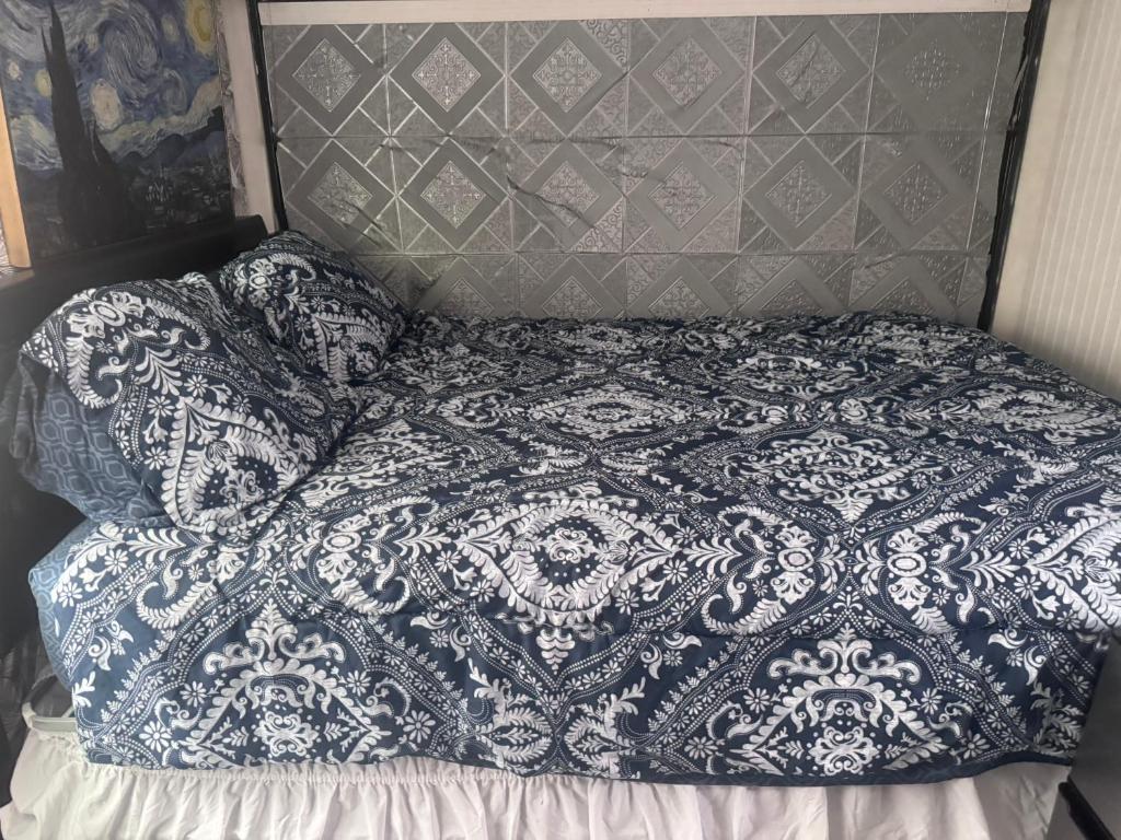 ein Bett mit einer blau-weißen Decke darauf in der Unterkunft Comfy camper in Tampa