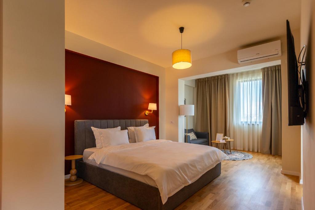 a hotel room with a large bed and a window at Habitat Suites III in Craiova