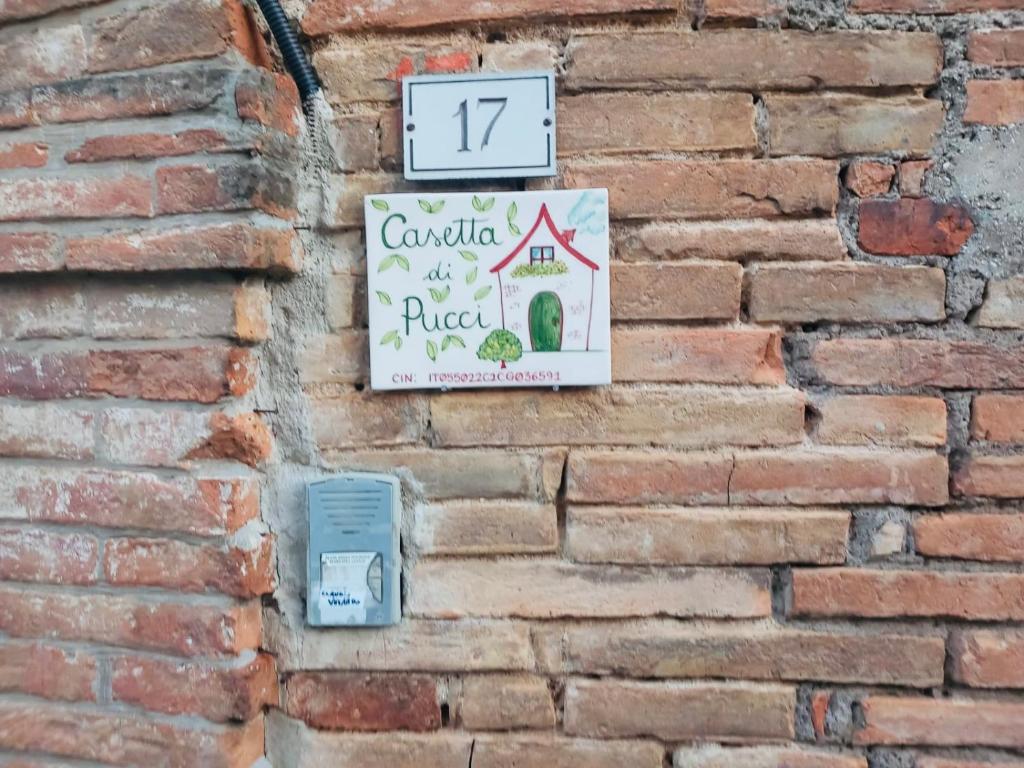 a clock on a brick wall with a sign on it at Casetta di Pucci in Capitone