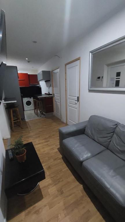 a living room with a couch and a table at 1A chambre confortable 02 in Audun-le-Tiche