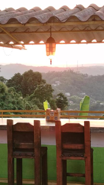 two chairs sitting at a table with a view at Los Arrieros - Hospedaje Rural in Manizales