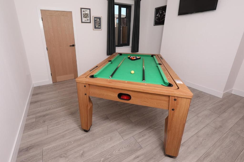 a wooden table with a green snooker table at Spacious 6-Guest Retreat with Pool Table in Dinnington