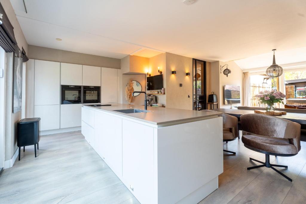 a kitchen with white cabinets and a kitchen island at Hoek de luxe in Zoetermeer