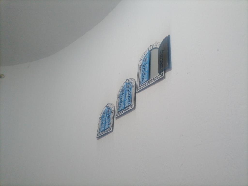 four plates on a wall with a television on it at Beach lodge in Chebba