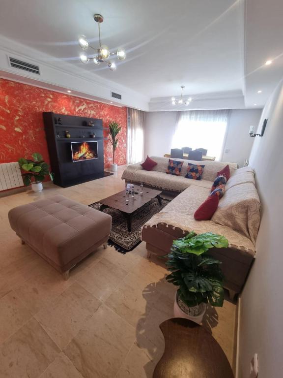 a living room with a couch and a fireplace at Appartement de luxe in Sidi Daoud