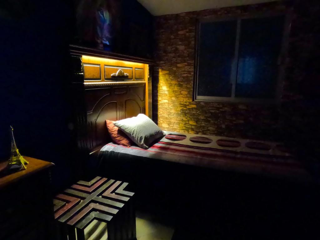 a dark room with a couch and a window at Cómoda habitación para descanso, La casa del artista in Toluca
