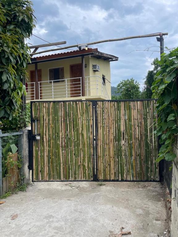 a house behind a fence with a gate at Kit net great price in São Sebastião