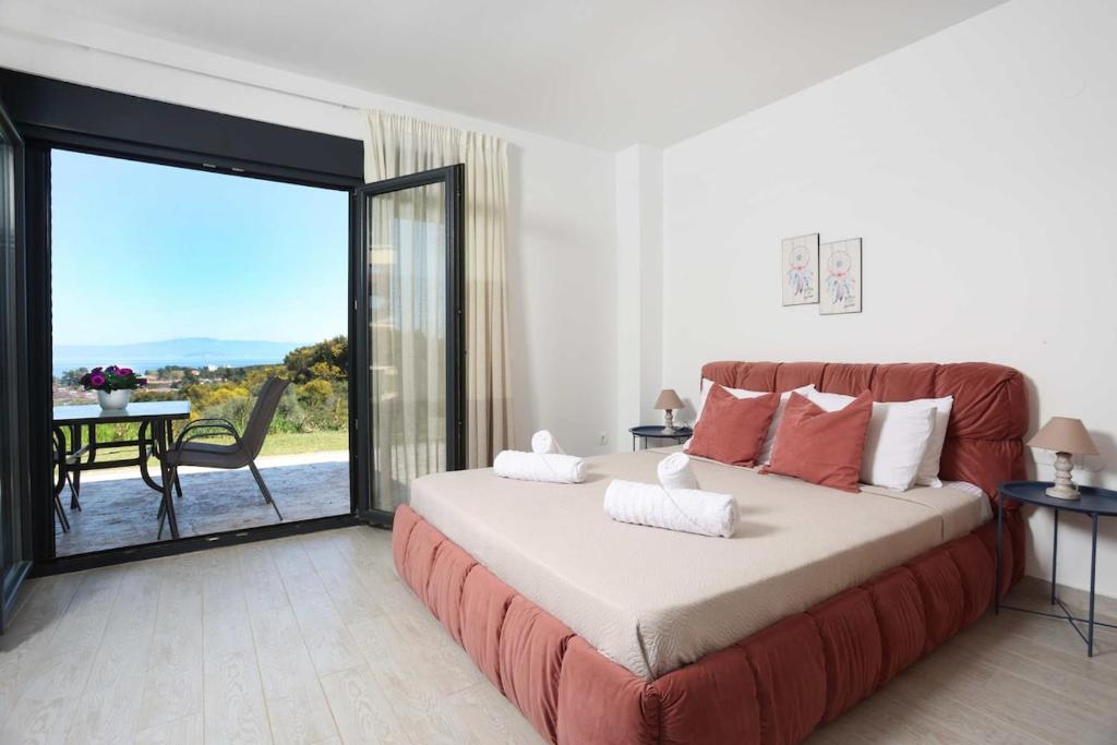 a bedroom with a large bed with a large sliding glass door at Hilltop Apartment 6 in Hanioti