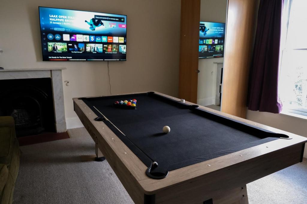 a pool table in a living room with a tv at Two Perfect for large groups and secured free parking in Reading
