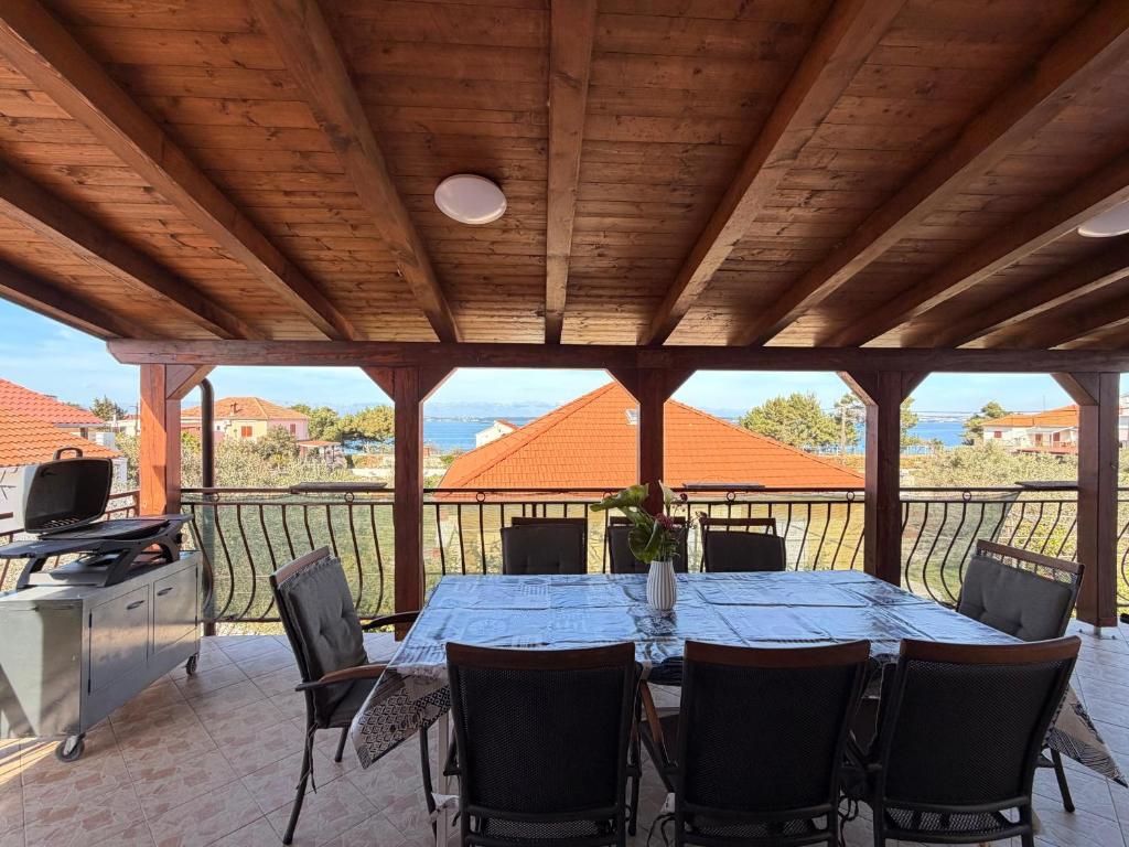 a dining table and chairs on a patio with a view at Apartments by the sea Ugljan - 8264 in Ugljan