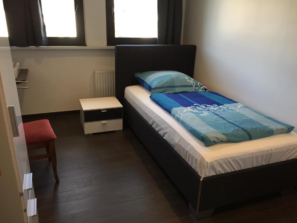 a bedroom with a bed with a blue comforter at Hotel Restaurant Kroatia in Dortmund