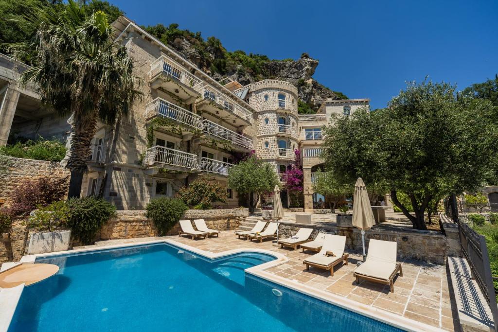 a hotel with a swimming pool in front of a building at Apartments Pietra Mare in Petrovac na Moru