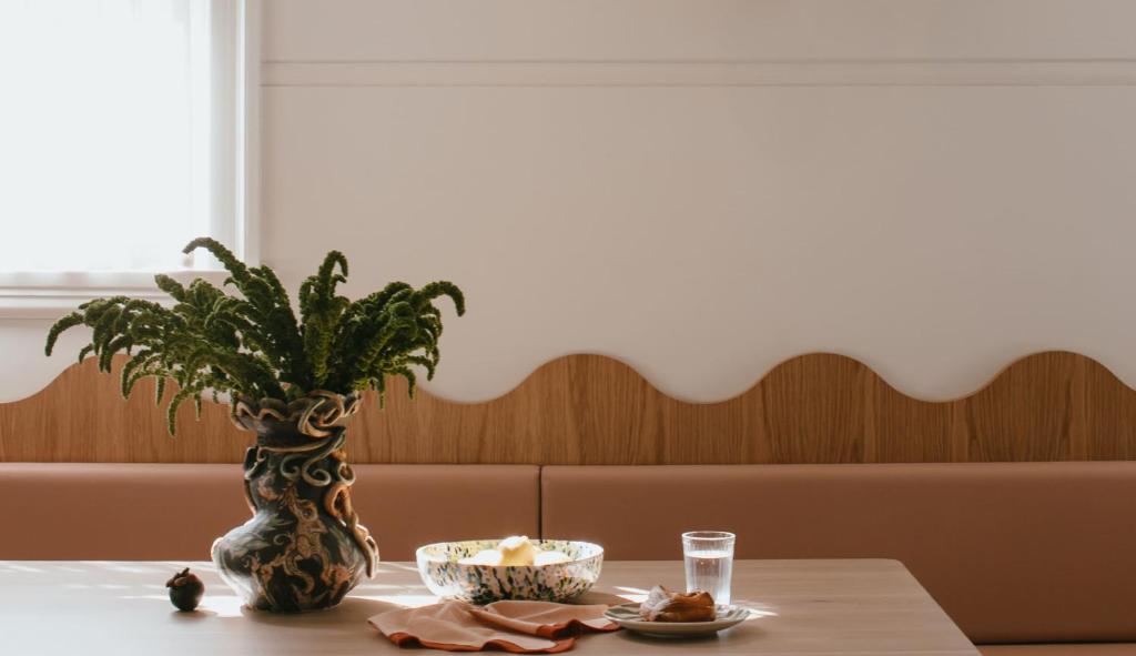 a table with a plant and a bowl of food on it at Sona Molong in Molong