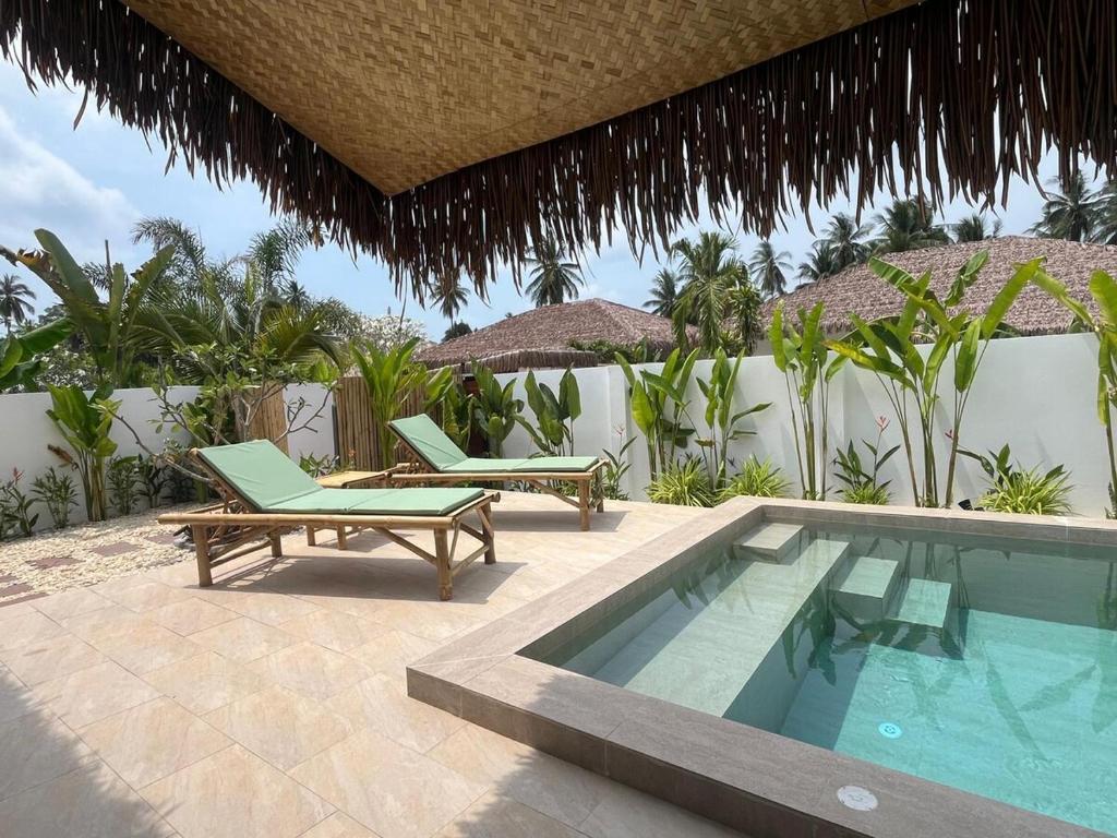 a swimming pool with two lounge chairs next to a house at Villa Sabaï • Private Pool • Thong Krut in Nathon Bay