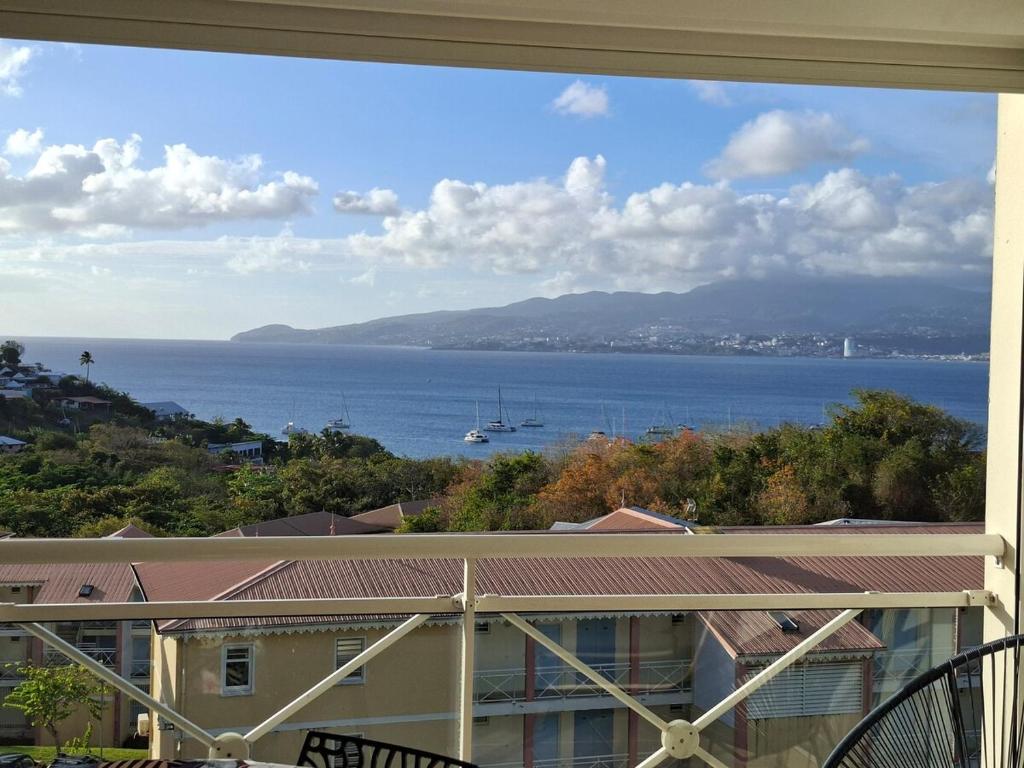 a view of the ocean from a balcony at Studio vu sur les caraïbes in Les Trois-Îlets
