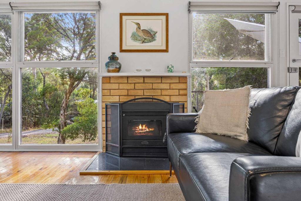 a living room with a couch and a fireplace at Wattletree Cottage Halls Gap in Halls Gap