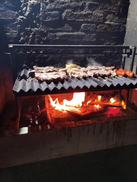 a grill with food cooking on top of it at Cabaña Rústica en Papudo in Papudo