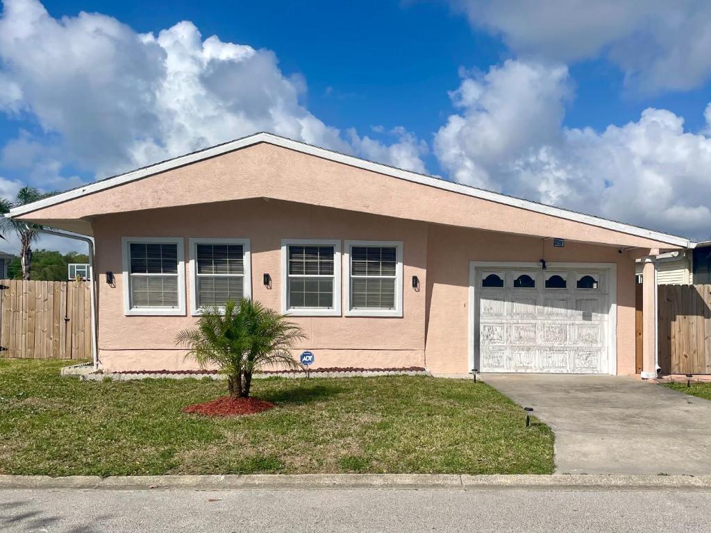 a pink house with a tree in front of it at Mia Rose in South Daytona