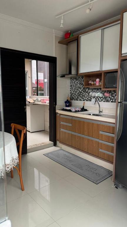 a kitchen with a sink and a refrigerator at Apartamento de 2 quartos no centro de Garopaba in Garopaba