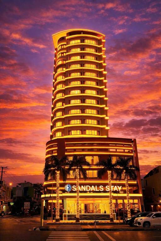 a tall building with a sign on it at sunset at Sandals Stay Hotel in Danang