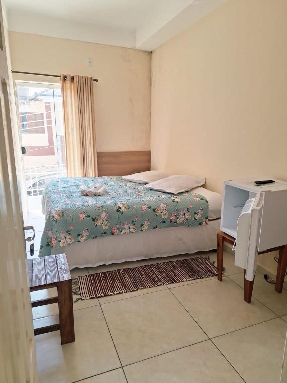 a small bedroom with a bed and a window at Pousada Morada in Aparecida