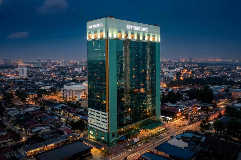 a tall green building in a city at night at New York Hotel in Johor Bahru