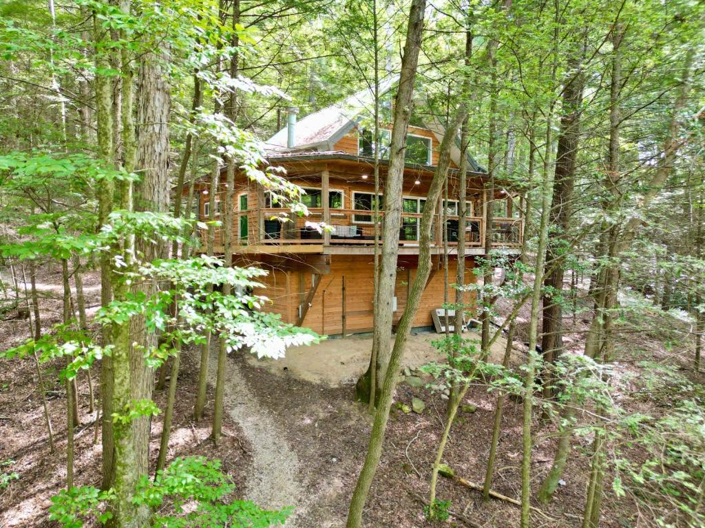 a log cabin in the woods with trees at The Founder - Iconic Rockhouse Cabin in Campton