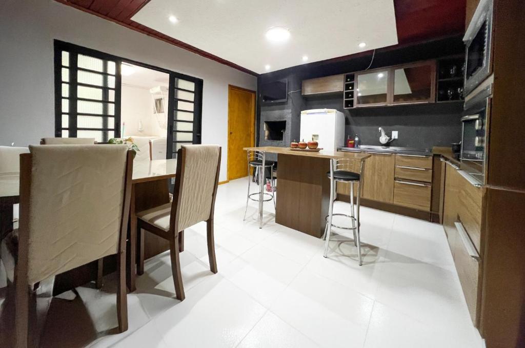 a kitchen with a table and chairs in a room at Casa completa em Bagé ideal para familias ate 6 pessoas WiFi e excelente localização in Bagé