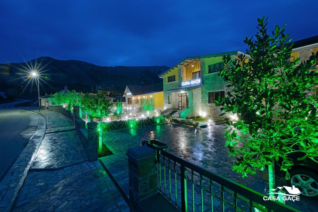 Una ciudad de noche con luces en el agua en Casa Gaçe Hotel, en Korçë