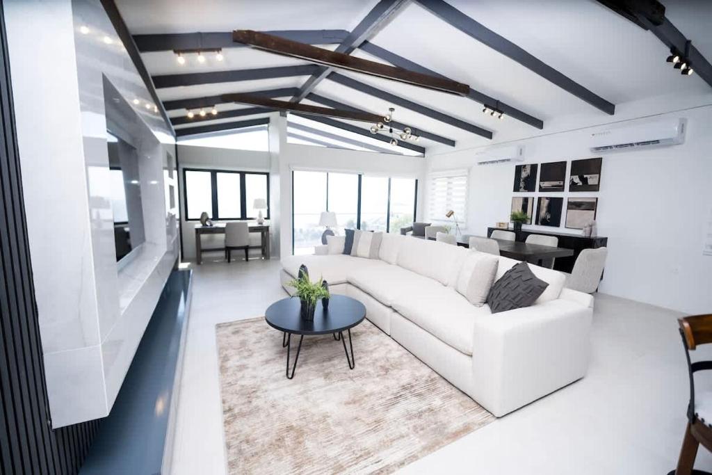 a living room with a white couch and a table at Avaya Oasis - Villa Trinidad in Carenage