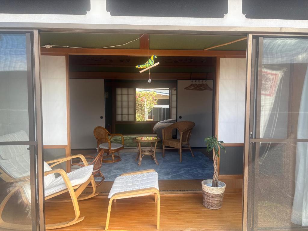 a screened in porch with chairs and a table at Ohana in Kuroshio