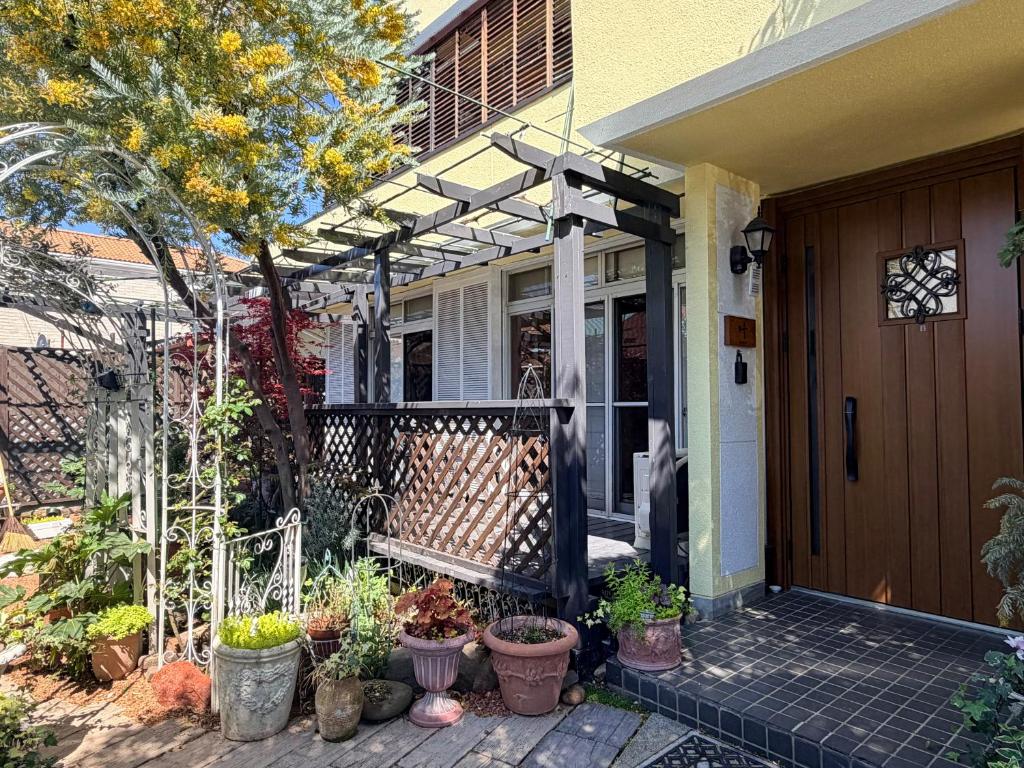 Eine Veranda mit einer Bank und Topfpflanzen in der Unterkunft 叶 in Nishikichō