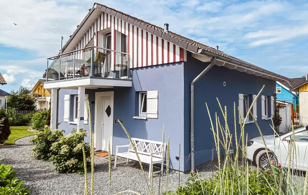 a blue house with a balcony and a car at Seebrise B in Süssau