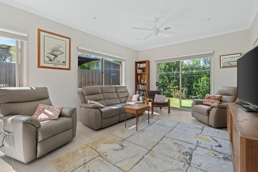 a living room with two couches and a tv at The Buckleys Escape in Point Lonsdale