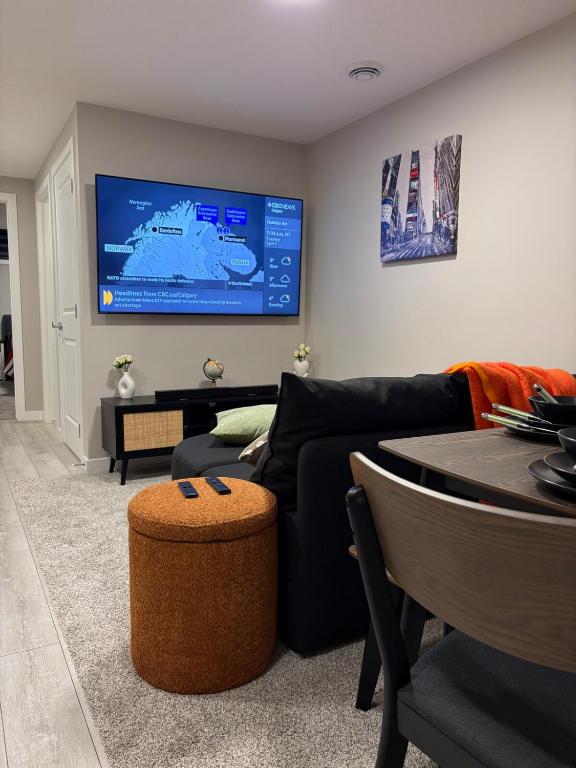 a living room with a black couch and a table at Beyond comfort - arriveYYC in YYC
