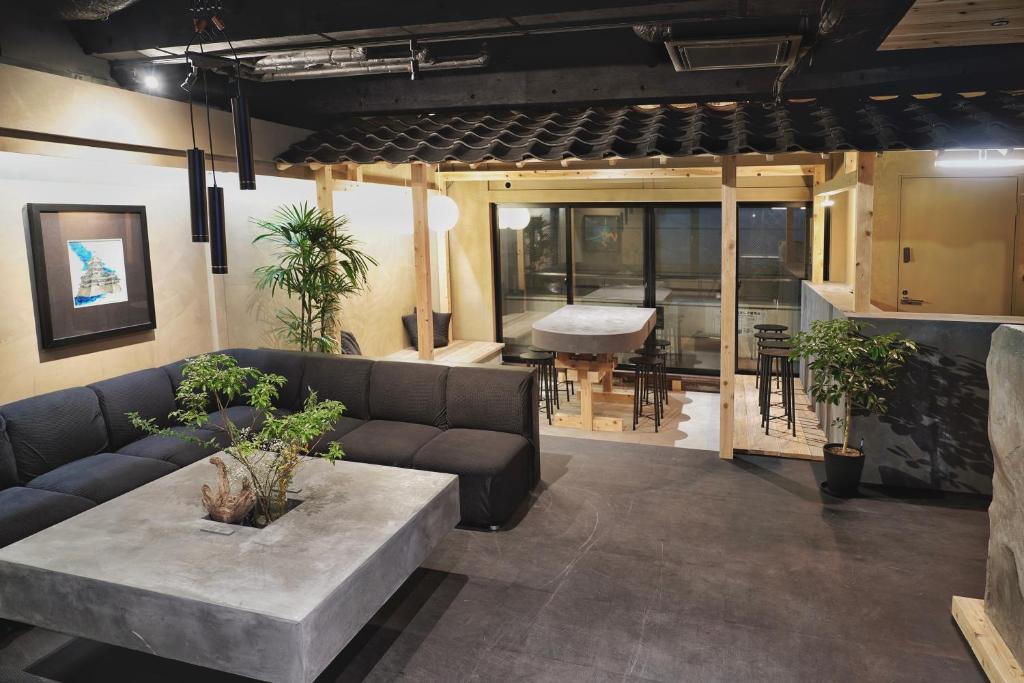 a living room with a couch and a table at MATSUMOTO CASTLE hostel in Matsumoto
