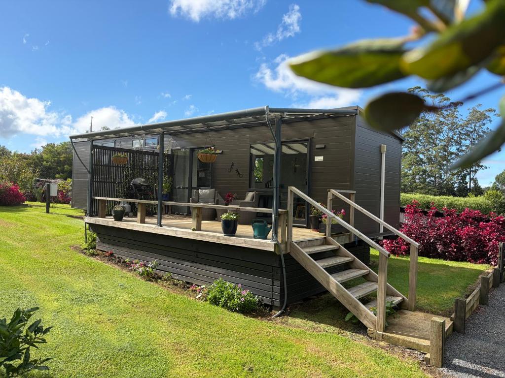 a black tiny house with a porch and stairs at BB'S Cabin in Kerikeri