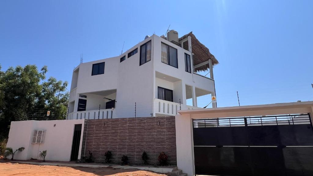 a large white house on top of a garage at Casa Braiden in Malucano