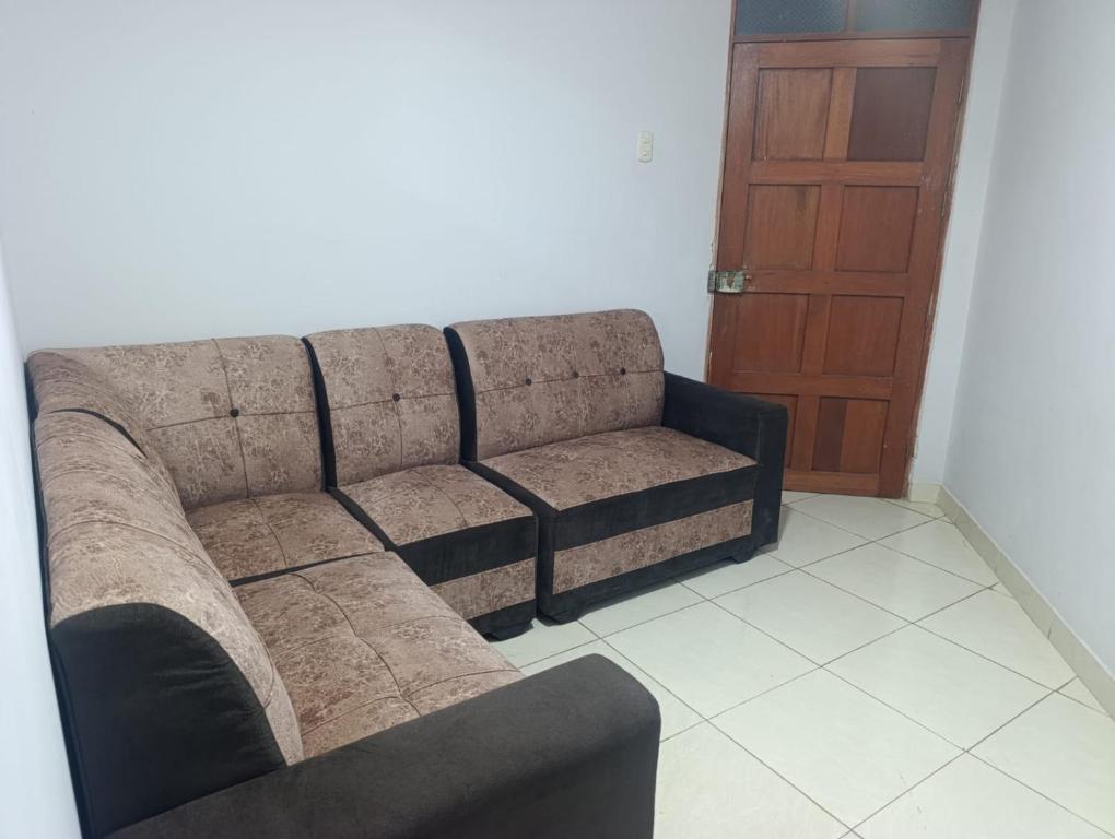 a couch in a living room with a door at Minidepartamento Centro de Huanuco in Huánuco