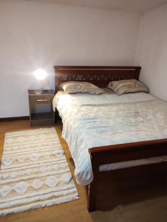 a bedroom with a bed and a nightstand and a bed sidx sidx sidx sidx at Hospedaje Alondra in Osorno