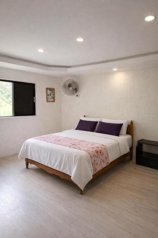 a bedroom with a large bed and a flat screen tv at Refugio Rio Santo in Las Alfombras