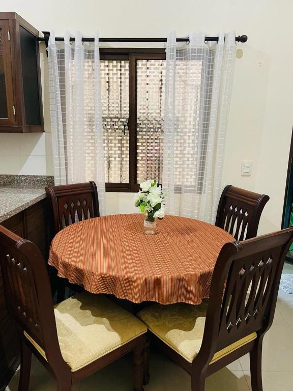 a dining room table with a vase of flowers on it at Mi casita en Jaraba in Jarabacoa