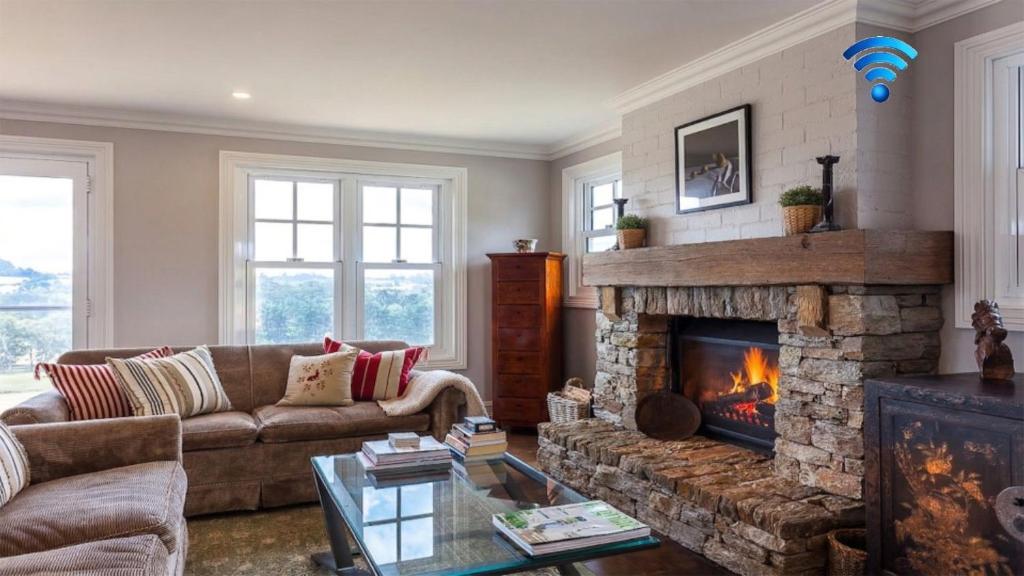 a living room with a couch and a fireplace at Somerleyton Cottage in Wildes Meadow