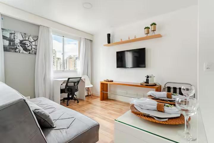 a living room with a couch and a table at Flat Hotel Vila Olímpia in São Paulo