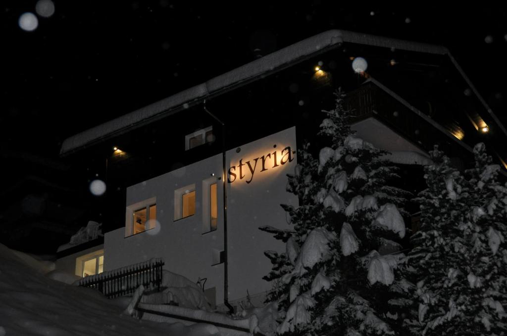 a building with a sign on it in the snow at Apartments Styria in Zermatt