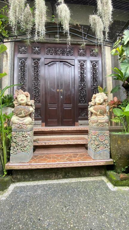 a wooden door with a bench in front of it at Wina Ubud B&B in Ubud