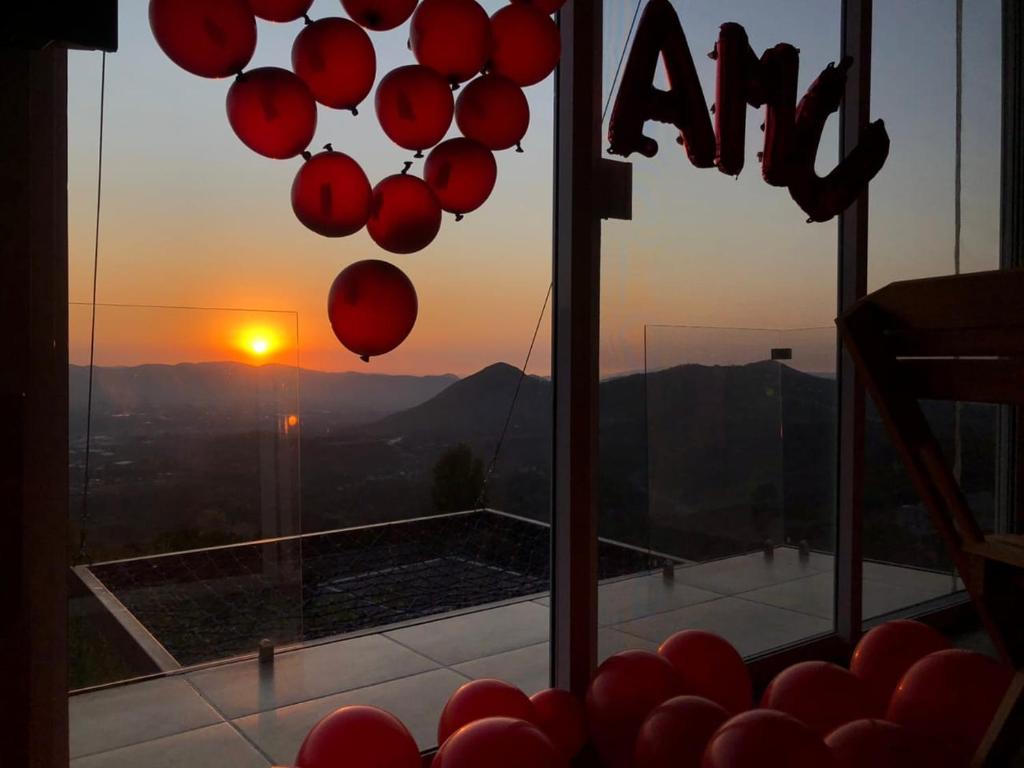 a view of the sunset from a room with balloons at Amanecer Ixtapan de la Sal in Ixtapan de la Sal